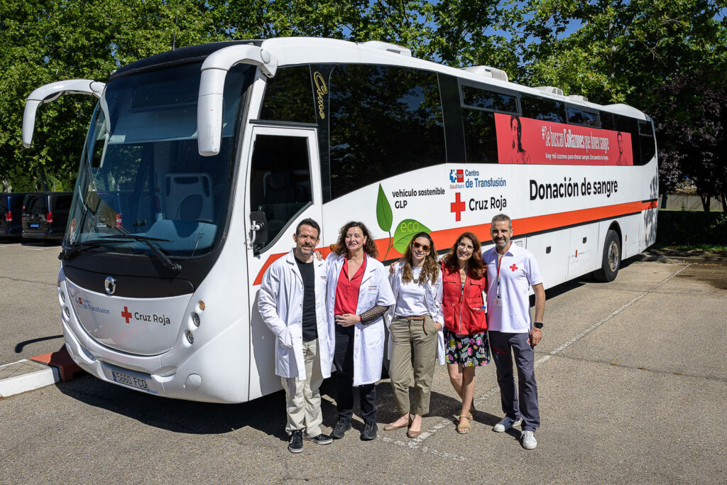 Five members of staff standing next to a blood donation coach during EHA2024.