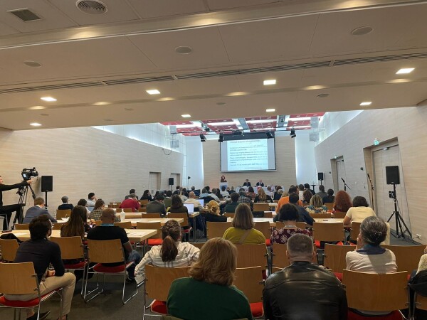 A presentation at the SWG meeting with attendees seated in the audience.