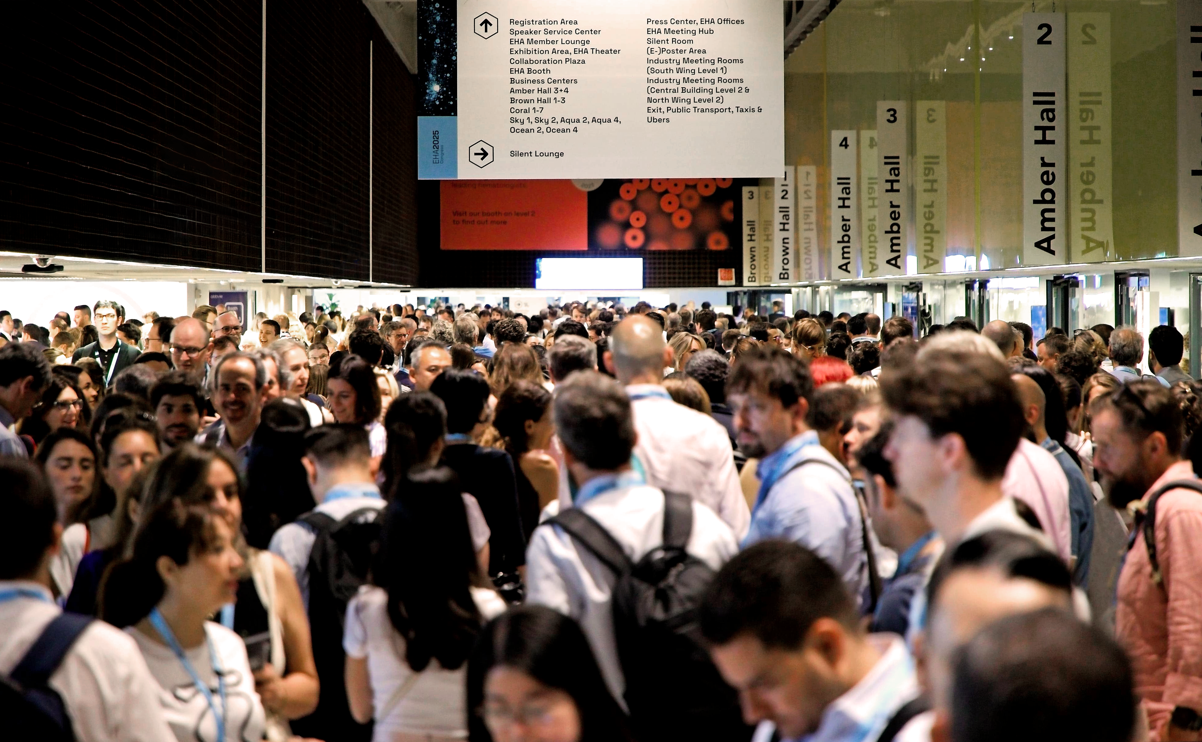 Dozens of delegates mingling outside of exhibition halls at EHA2025.